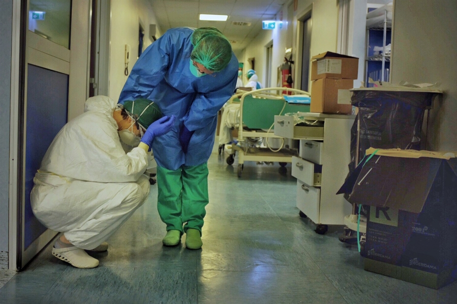 Two intensive care professionals comfort each other in the ICU of a hospital in Cremona, Italy, on Friday, March 13, 2020.